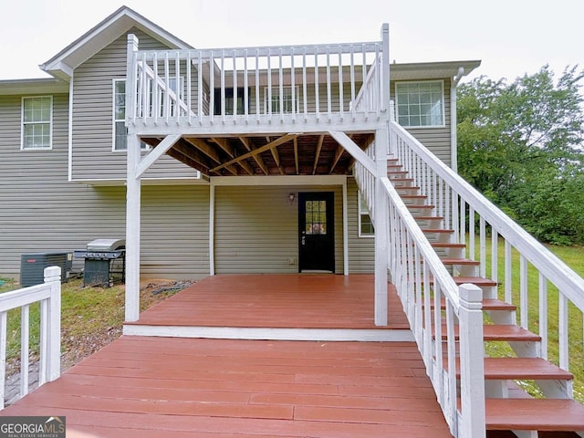 wooden terrace with stairs, cooling unit, and area for grilling