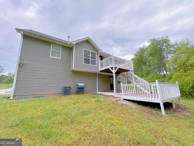 back of property with stairway, a yard, and a wooden deck