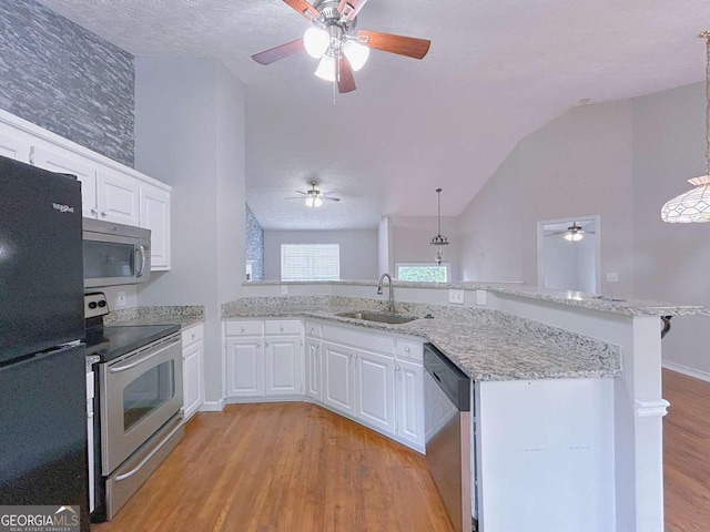 kitchen featuring a ceiling fan, a sink, appliances with stainless steel finishes, and vaulted ceiling