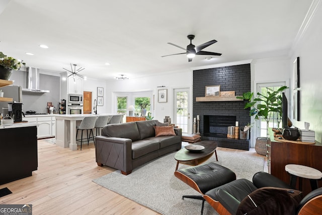 109 Old Virginia Cir, Jonesboro, GA 30236 - living room featuring a brick fireplace, light wood finished floors, a ceiling fan, ornamental molding, and recessed lighting