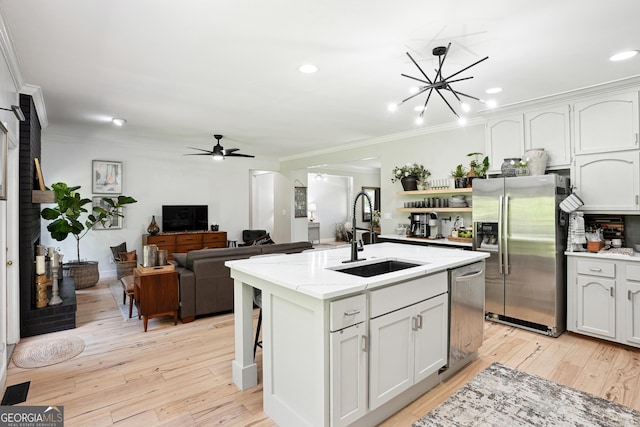 109 Old Virginia Cir, Jonesboro, GA 30236 - kitchen with appliances with stainless steel finishes, a sink, ornamental molding, light wood-type flooring, and a center island with sink