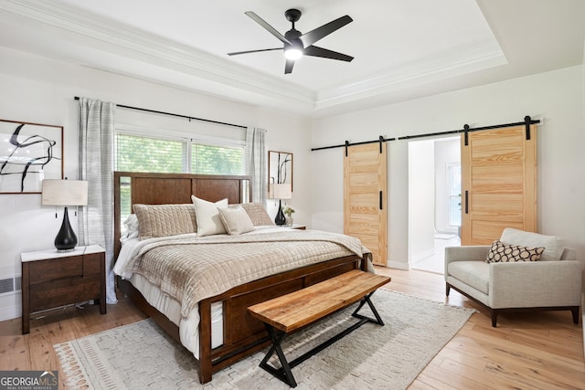 109 Old Virginia Cir, Jonesboro, GA 30236 - bedroom with a barn door, a raised ceiling, ornamental molding, light wood-style floors, and baseboards
