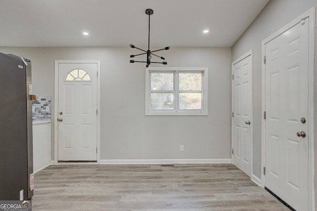 foyer entrance featuring an inviting chandelier, recessed lighting, and light wood-style flooring