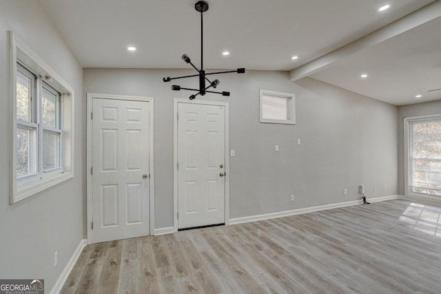 interior space featuring an inviting chandelier, lofted ceiling with beams, recessed lighting, baseboards, and wood finished floors