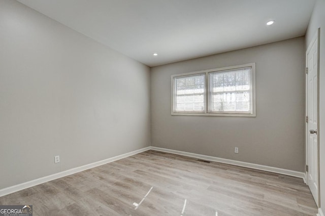 unfurnished room featuring baseboards, recessed lighting, wood finished floors, and visible vents