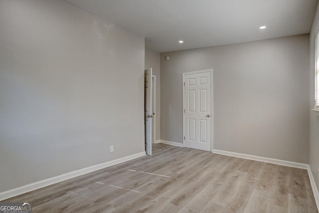 unfurnished room with recessed lighting, baseboards, and light wood-style floors