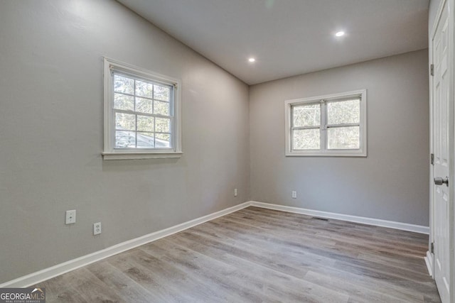 empty room with recessed lighting, baseboards, visible vents, and wood finished floors