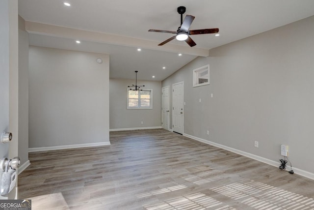 spare room with a ceiling fan, baseboards, lofted ceiling with beams, light wood finished floors, and recessed lighting