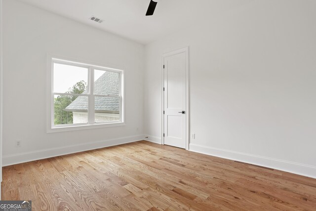 unfurnished room with visible vents, a ceiling fan, light wood-style floors, and baseboards