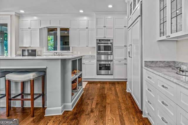 kitchen with white cabinetry, dark wood-style flooring, a warming drawer, and glass insert cabinets