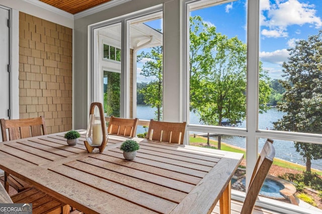 sunroom / solarium featuring crown molding, a water view, and a wealth of natural light