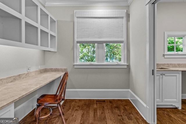 unfurnished office featuring baseboards, ornamental molding, and dark wood-style floors