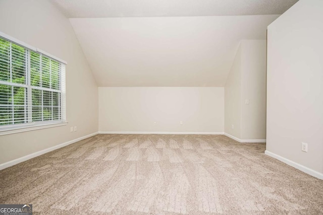 bonus room featuring carpet floors, baseboards, and lofted ceiling