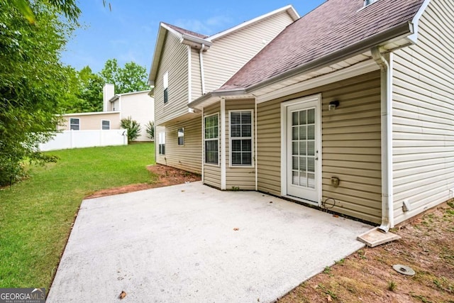 back of property featuring a lawn, fence, a patio, and a shingled roof