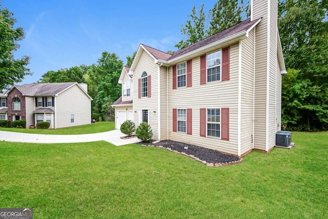 view of front of home with a chimney, driveway, central AC, and a front yard