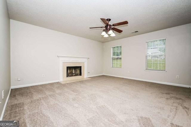 unfurnished living room with baseboards, a ceiling fan, carpet flooring, and visible vents