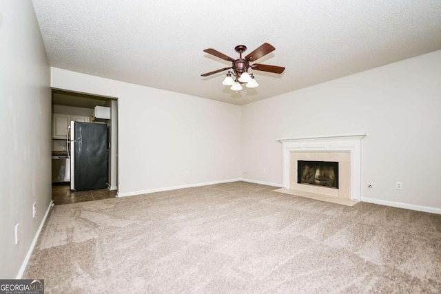 unfurnished living room featuring carpet floors, ceiling fan, baseboards, and a premium fireplace