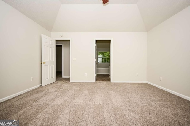unfurnished bedroom with carpet floors, baseboards, and vaulted ceiling