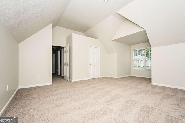bonus room featuring carpet floors, baseboards, and lofted ceiling
