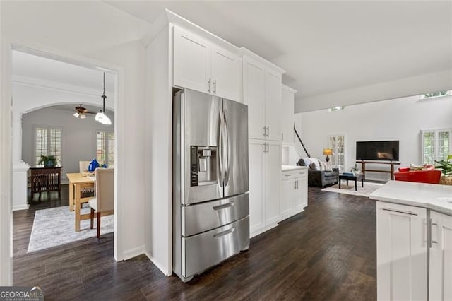 kitchen with stainless steel fridge, light countertops, white cabinetry, and dark wood-type flooring