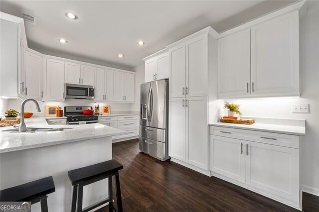 kitchen with recessed lighting, a sink, white cabinetry, and stainless steel appliances