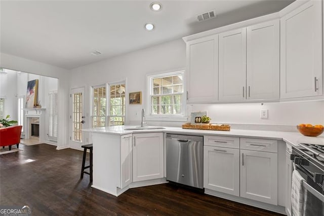 kitchen with stainless steel dishwasher, visible vents, black gas range, white cabinets, and a sink