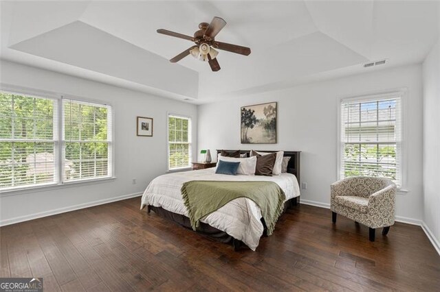 bedroom featuring baseboards, a ceiling fan, hardwood / wood-style floors, and visible vents
