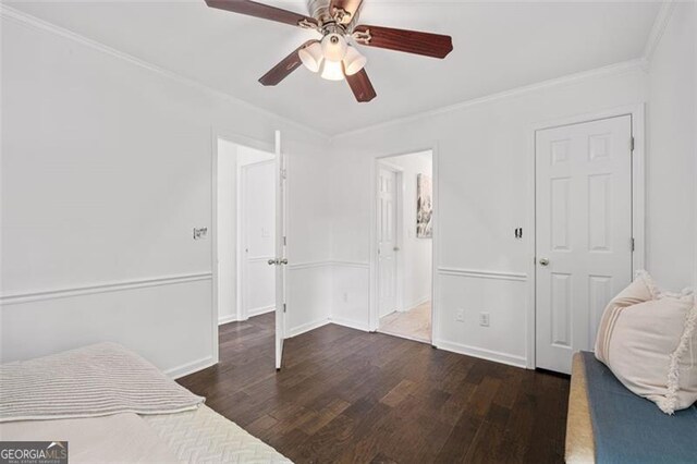 unfurnished bedroom with crown molding, baseboards, ceiling fan, and wood finished floors