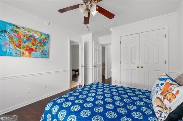 bedroom with crown molding, baseboards, wood finished floors, and a closet
