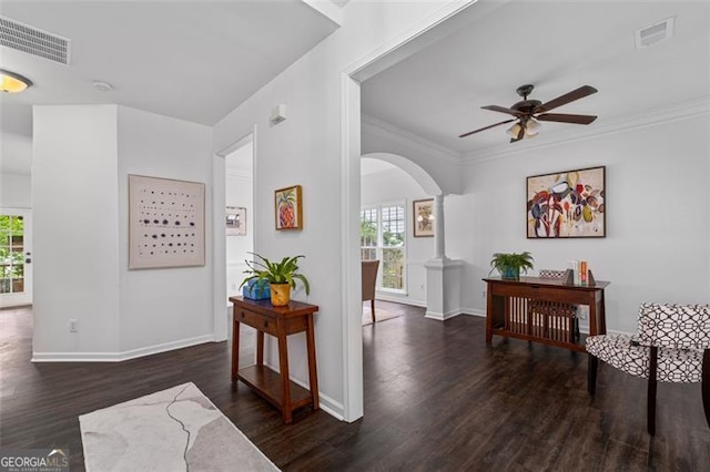hallway featuring arched walkways, visible vents, plenty of natural light, and wood finished floors