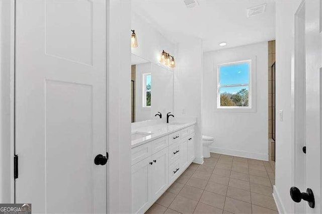 full bath with double vanity, baseboards, a healthy amount of sunlight, and tile patterned flooring