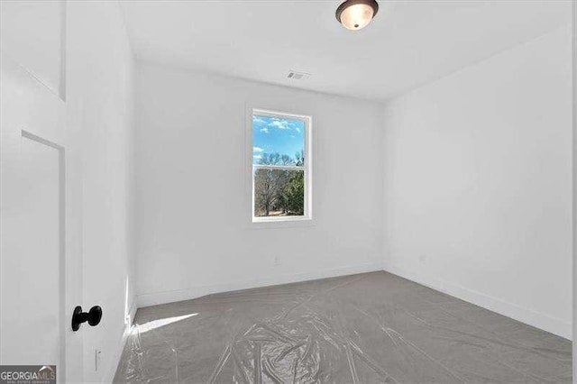 spare room with baseboards and visible vents