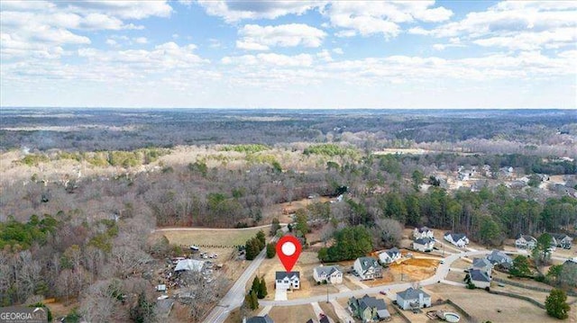 birds eye view of property featuring a forest view