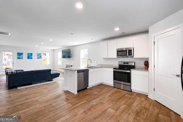 1341 Midnight Ride Ct, Hampton, GA 30228 - kitchen with visible vents, appliances with stainless steel finishes, a sink, a peninsula, and open floor plan