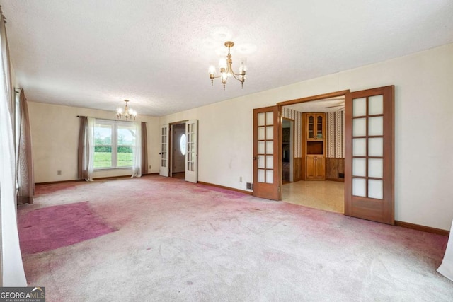 6545 Westbrook Rd, Gainesville, GA 30506 - carpeted empty room with an inviting chandelier, baseboards, french doors, and a textured ceiling