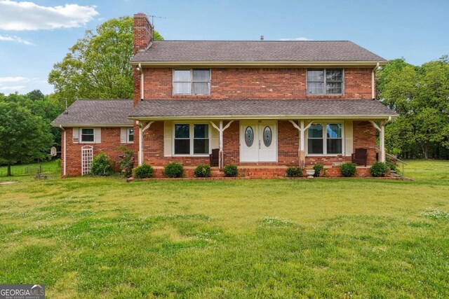 6545 Westbrook Rd, Gainesville, GA 30506 - traditional-style home with brick siding, a chimney, a front yard, and roof with shingles