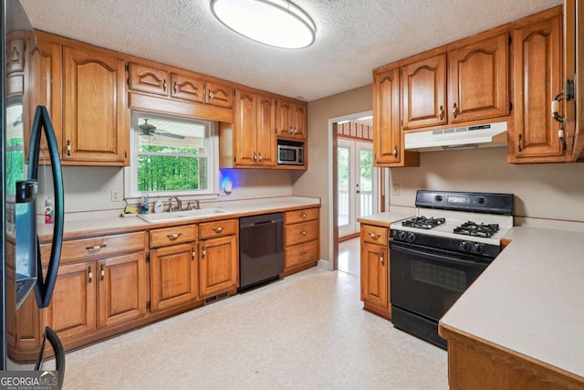 6545 Westbrook Rd, Gainesville, GA 30506 - kitchen featuring brown cabinetry, light countertops, under cabinet range hood, a sink, and black appliances