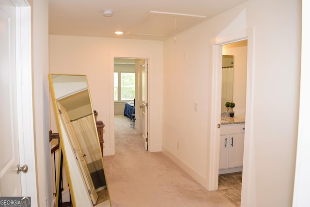 corridor with light colored carpet, attic access, baseboards, and recessed lighting