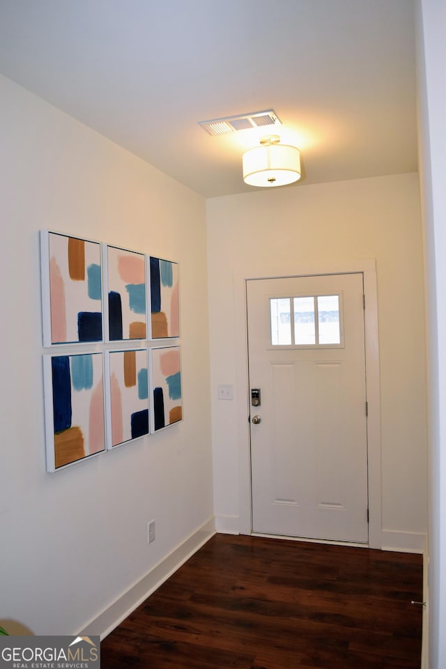 foyer featuring baseboards, dark wood-style flooring, and visible vents