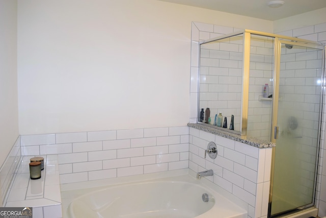 bathroom featuring a shower stall and a bath