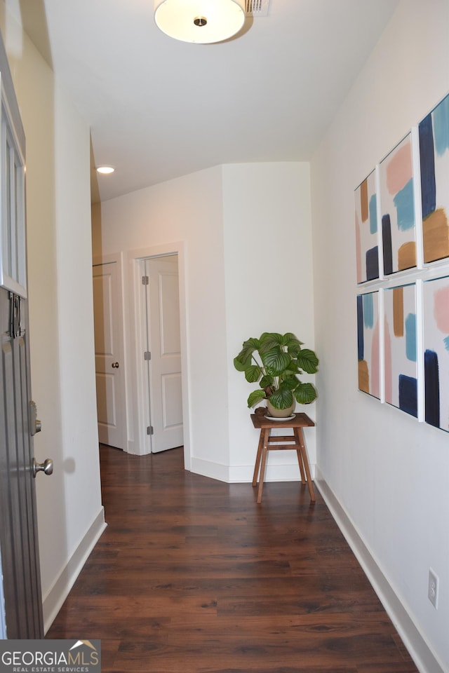 hallway with baseboards and wood finished floors