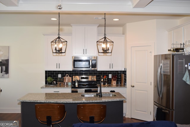 kitchen featuring white cabinets, tasteful backsplash, light stone countertops, and stainless steel appliances