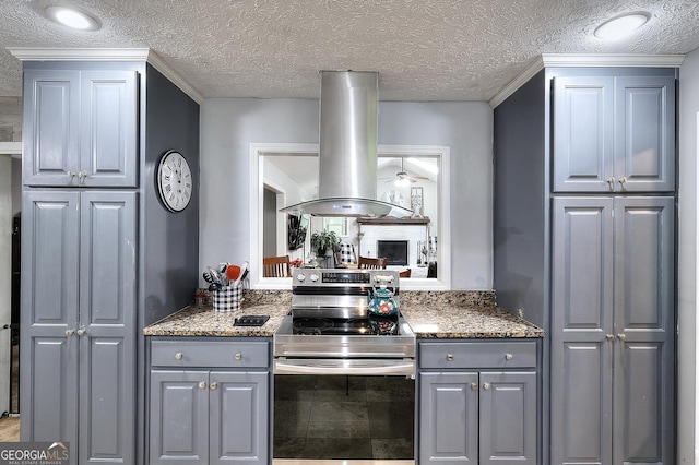 kitchen with island exhaust hood, electric stove, gray cabinets, and ceiling fan