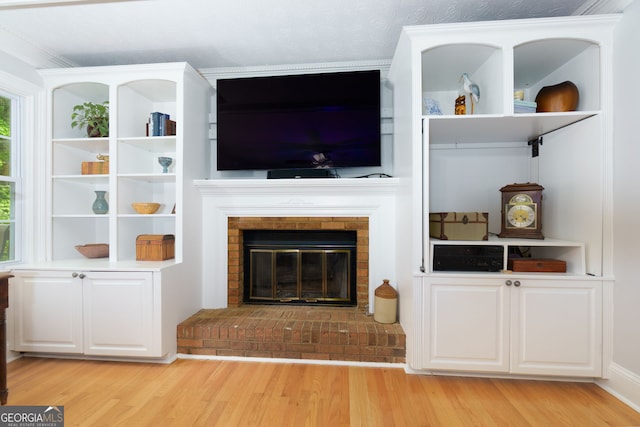 unfurnished living room with a brick fireplace and light wood finished floors