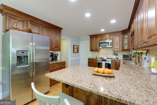 kitchen with backsplash, crown molding, appliances with stainless steel finishes, a sink, and a peninsula