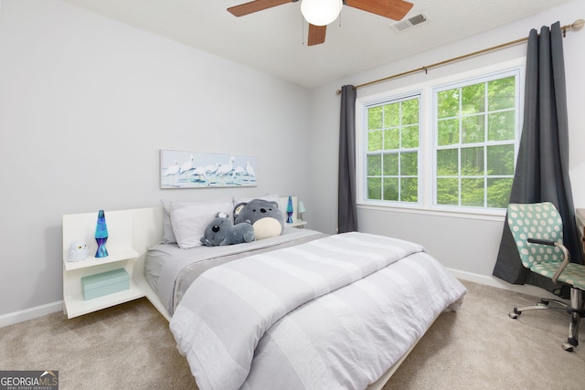 carpeted bedroom with baseboards, a ceiling fan, and visible vents