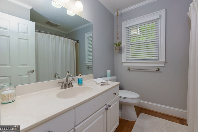 bathroom with crown molding, vanity, wood finished floors, toilet, and baseboards