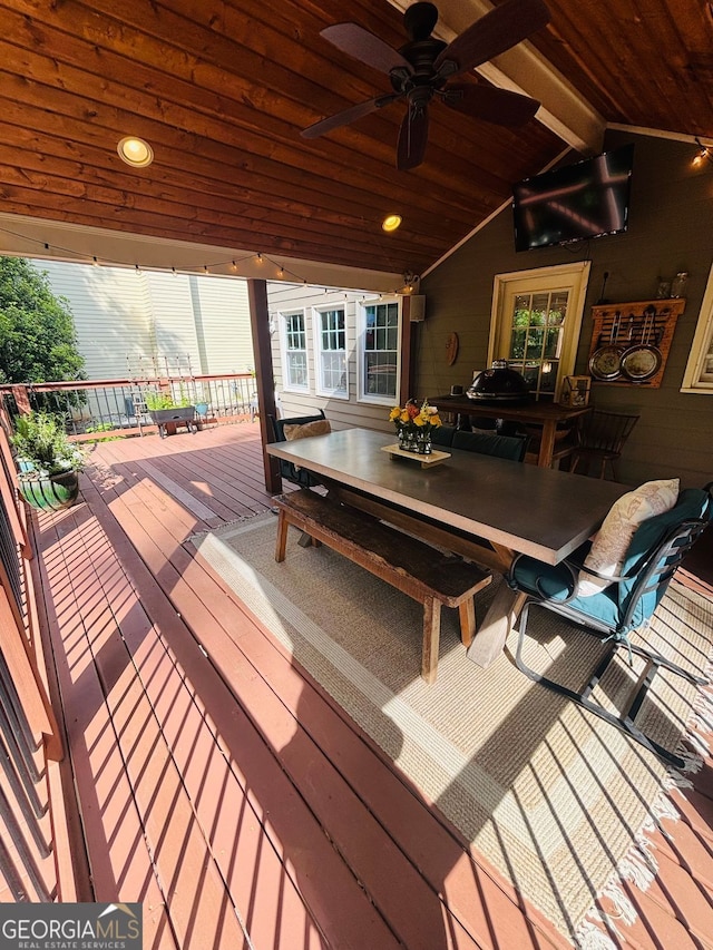wooden deck featuring outdoor dining area and a ceiling fan