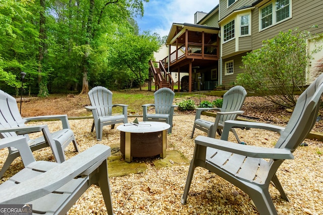 view of yard featuring a deck, an outdoor fire pit, and stairway