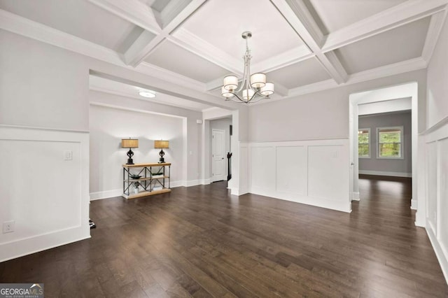 unfurnished dining area with an inviting chandelier, coffered ceiling, dark wood-type flooring, and beamed ceiling